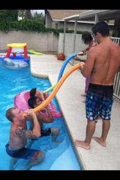 two men are playing in the pool with an inflatable tube