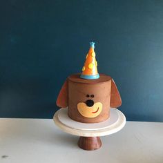 a cake shaped like a dog wearing a party hat