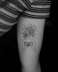 a woman's arm with flowers on it and a bow in the middle of her arm