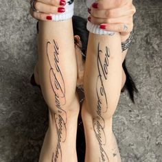 two women with tattoos on their arms and legs, both holding onto one another's hands