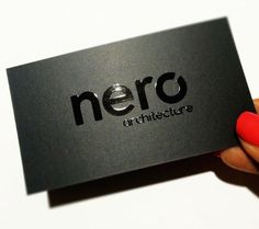 a person holding up a business card with the word nero on it in black