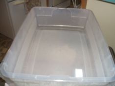 a large plastic container sitting on top of a counter next to a refrigerator freezer