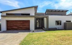 a white house with brown garage doors and windows