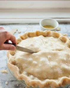 a person cutting into a pie with a knife