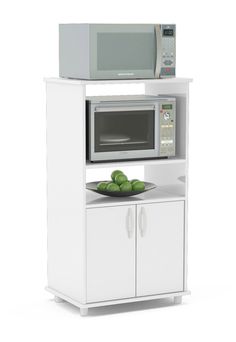 a microwave oven sitting on top of a cabinet with green apples in front of it