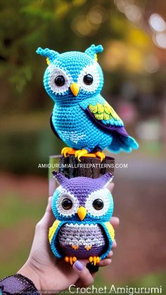 three crocheted owls sitting on top of each other in front of a tree