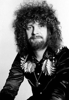 a man with long curly hair wearing a black shirt