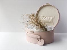 an open round box with flowers inside on a white surface