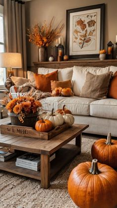 a living room filled with furniture and lots of pumpkins on the coffee table in front of it