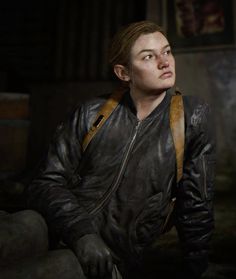 a woman in a leather jacket sitting down