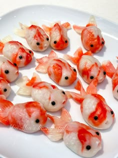 there are many small orange fish on the white plate, and one has black eyes