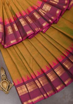 It is said that when weaving practices first began at Kanchipuram centuries back, the weavers used cotton as their primary base. Even though the Kanjivaram silk has taken predominance, the cotton sarees of this town have stood the test of time and have gained popularity. This all natural Kanchi cotton saree in an eye-pleasing color contrast carries the sophisticated charm that is attributed to sarees made in the looms of Kanjivaram. The wide border decorated with traditional motifs in zari enhan Saree Types, Kanchi Cotton Saree, Kalamkari Blouse, Cotton Sarees Online, Saree Designs Party Wear, Traditional Motifs, Embroidery Saree, Silk Cotton Sarees, Peacock Design