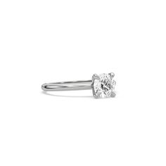 a white gold ring with a single diamond in the center, on a white background