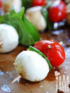 small appetizers with tomatoes, mozzarella and basil on a wooden board