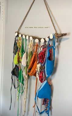 there are many bras hanging on the wall with strings attached to it and two hooks holding them