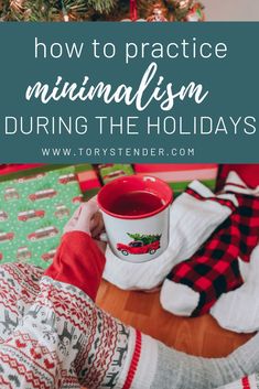 a person holding a mug with the words how to practice minimalism during the holidays