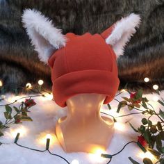 a red hat with white fur ears on top of a mannequin head