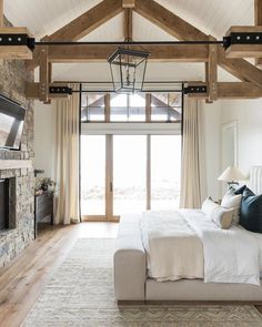 a bedroom with a large bed and stone fireplace