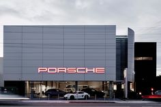 a porsche dealership with cars parked in front