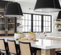 a large kitchen with lots of counter space and chairs around the island in front of it