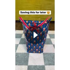 a large blue bag with santa clause on it sitting on top of a checkered floor