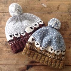 two knitted hats sitting on top of a wooden floor