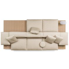 an overhead view of a couch with pillows on it and a table next to it