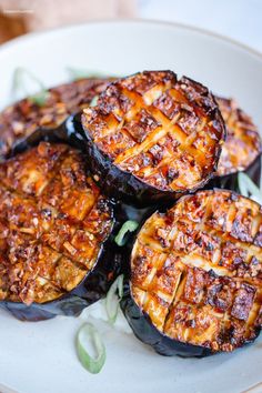 three stuffed eggplant halves on a white plate