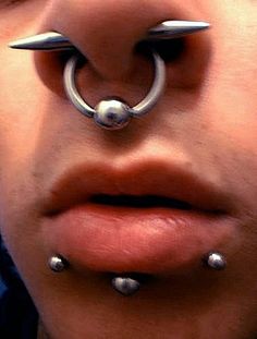 a man with piercings on his nose and nose ring in front of his face