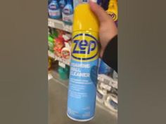 a person is holding a bottle of deodorant in front of a store shelf