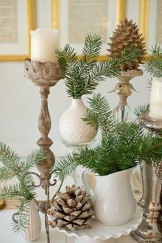 pine cones, candlesticks and other christmas decorations on a table