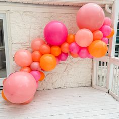 pink and orange balloons are on the front porch