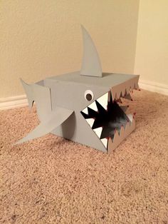 a cardboard shark with its mouth open on the floor