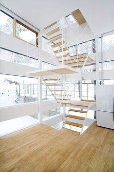 a staircase in the middle of a room with wood flooring and glass doors on both sides