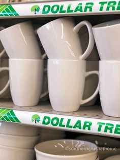 stacks of white coffee mugs with dollar tree stickers on them