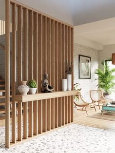 a living room with wooden slats and potted plants on the shelf next to it