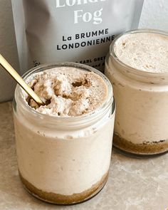 two jars filled with food sitting on top of a counter next to a bag of coffee