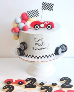 a birthday cake decorated with race cars and numbers