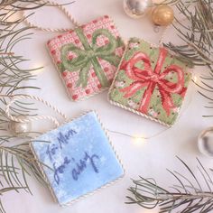 two christmas ornaments are sitting on a table