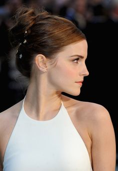 a close up of a person wearing a white dress and hair in a pony tail