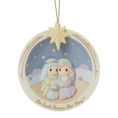 a christmas ornament with two children in the snow and a star on top