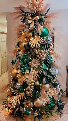 a christmas tree decorated with gold, green and silver ornaments