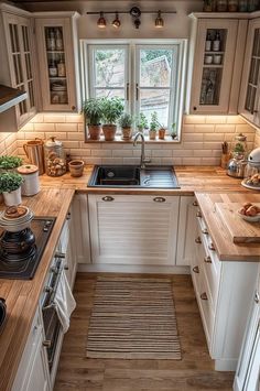 a kitchen with wooden counter tops and white cupboards next to a stove top oven