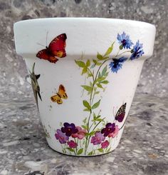 a flower pot with butterflies painted on it