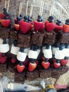 chocolate brownies with strawberries and marshmallows arranged on skewers