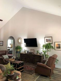 a living room filled with furniture and a flat screen tv mounted to the side of a wall