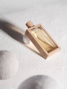 an empty bottle sitting on top of a white floor next to two large round balls