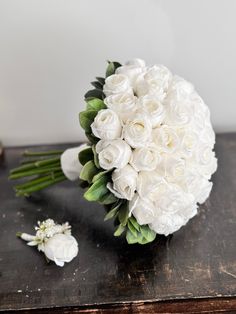 a bouquet of white flowers sitting on top of a wooden table