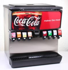 a coca - cola machine is shown with four different flavors