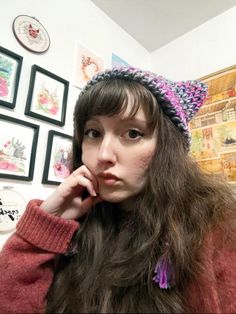 a woman with long hair wearing a knitted cat hat and looking at the camera